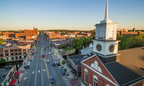 church's steeple looks over busy road in town